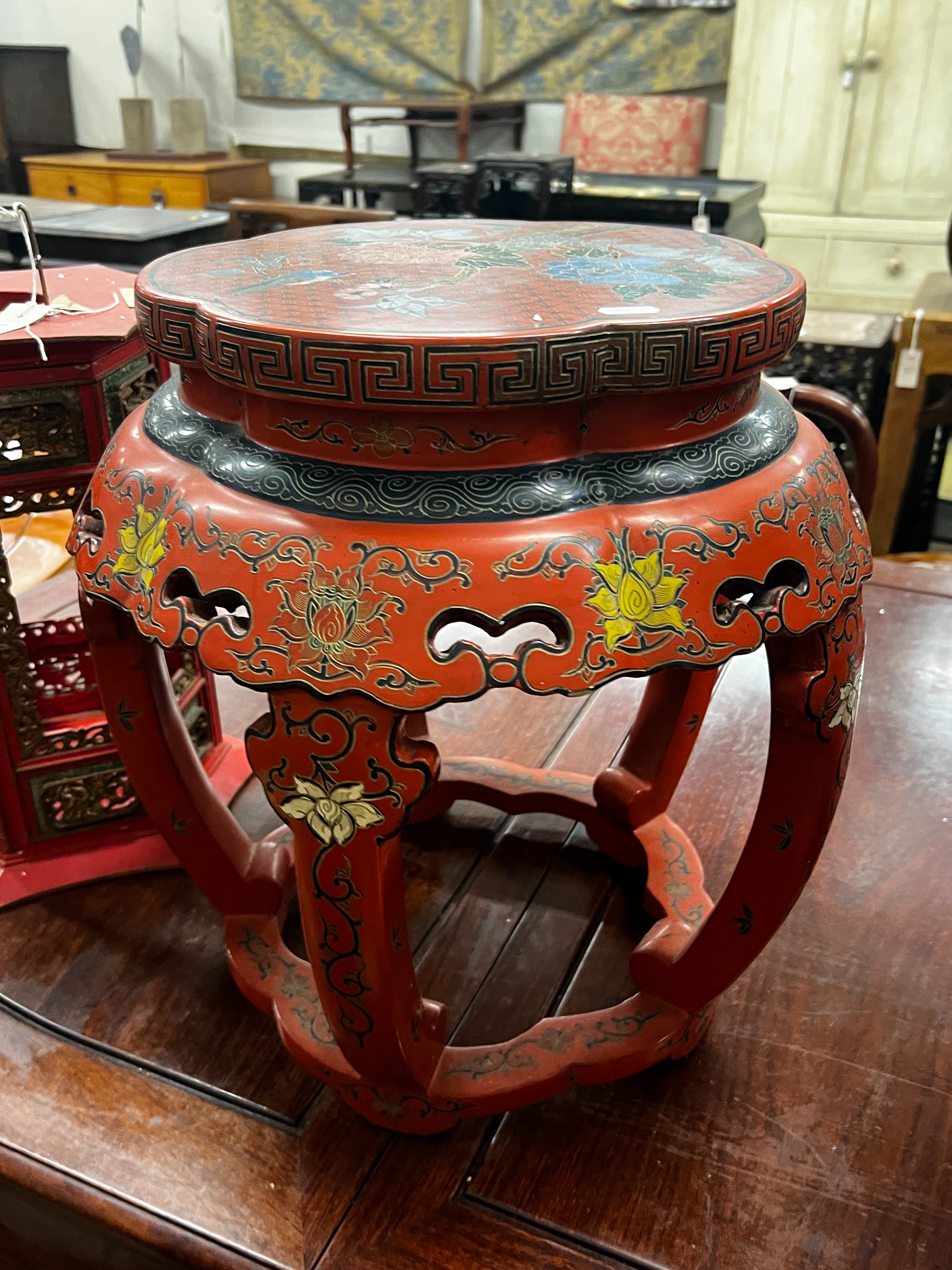 A Chinese red lacquer circular vase stand, diameter 44cm, height 47cm together with a similar Chinese red painted parcelgilt lantern, height 41cm